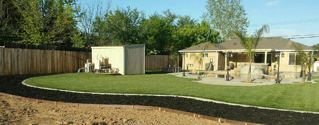 full view of backyard with artificial grass