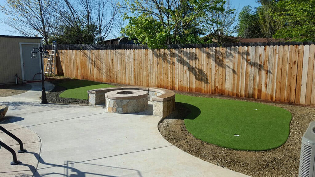 side view of putting green in corner of yard
